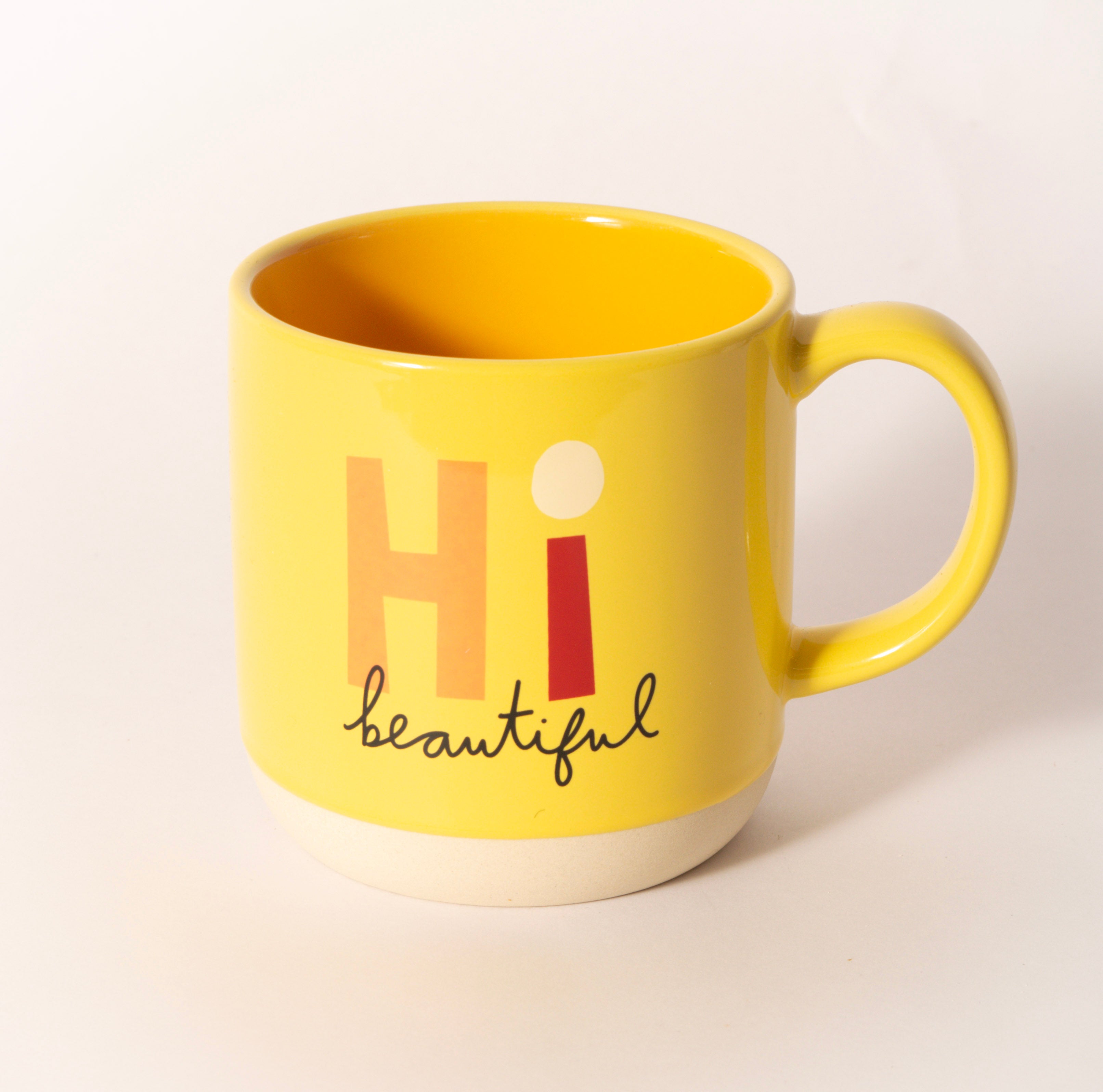 Yellow ceramic coffee mug printed with "Hi Beautiful," sold at Thistles in Pella, Iowa