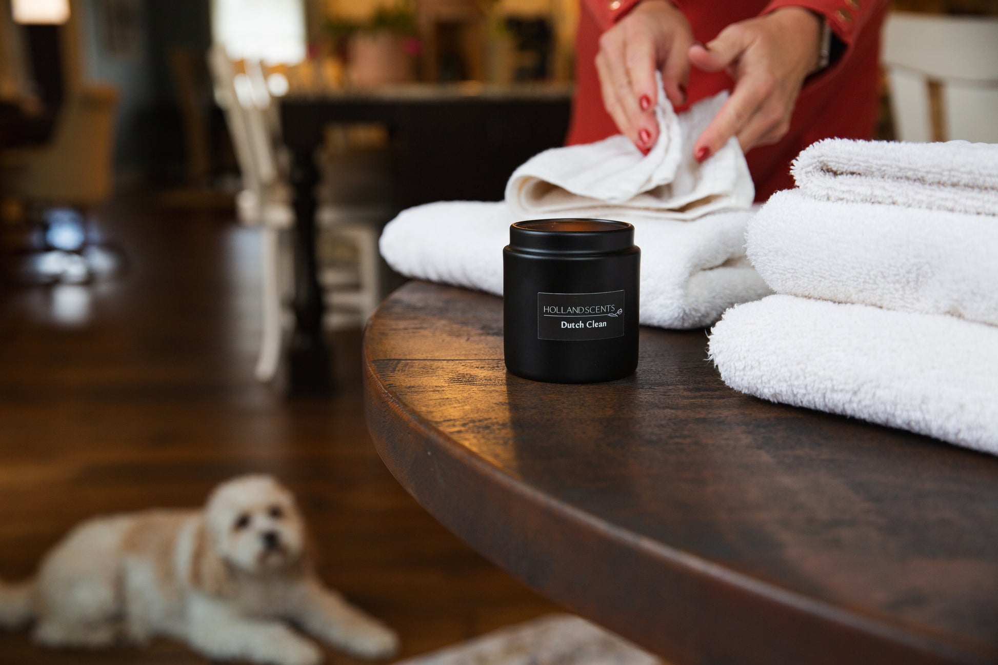 Holland Scents Dutch Clean soy candle on a table with folded towels and a dog in the background, Pella, Iowa