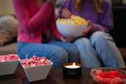 Holland Scents Dutch Girl soy candle lit on a table with pink candy and popcorn, Pella, Iowa