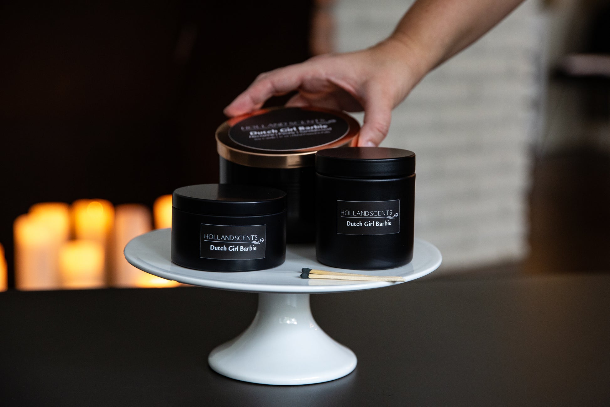 Holland Scents Dutch Girl soy candle in three sizes displayed on a cake stand, Pella, Iowa