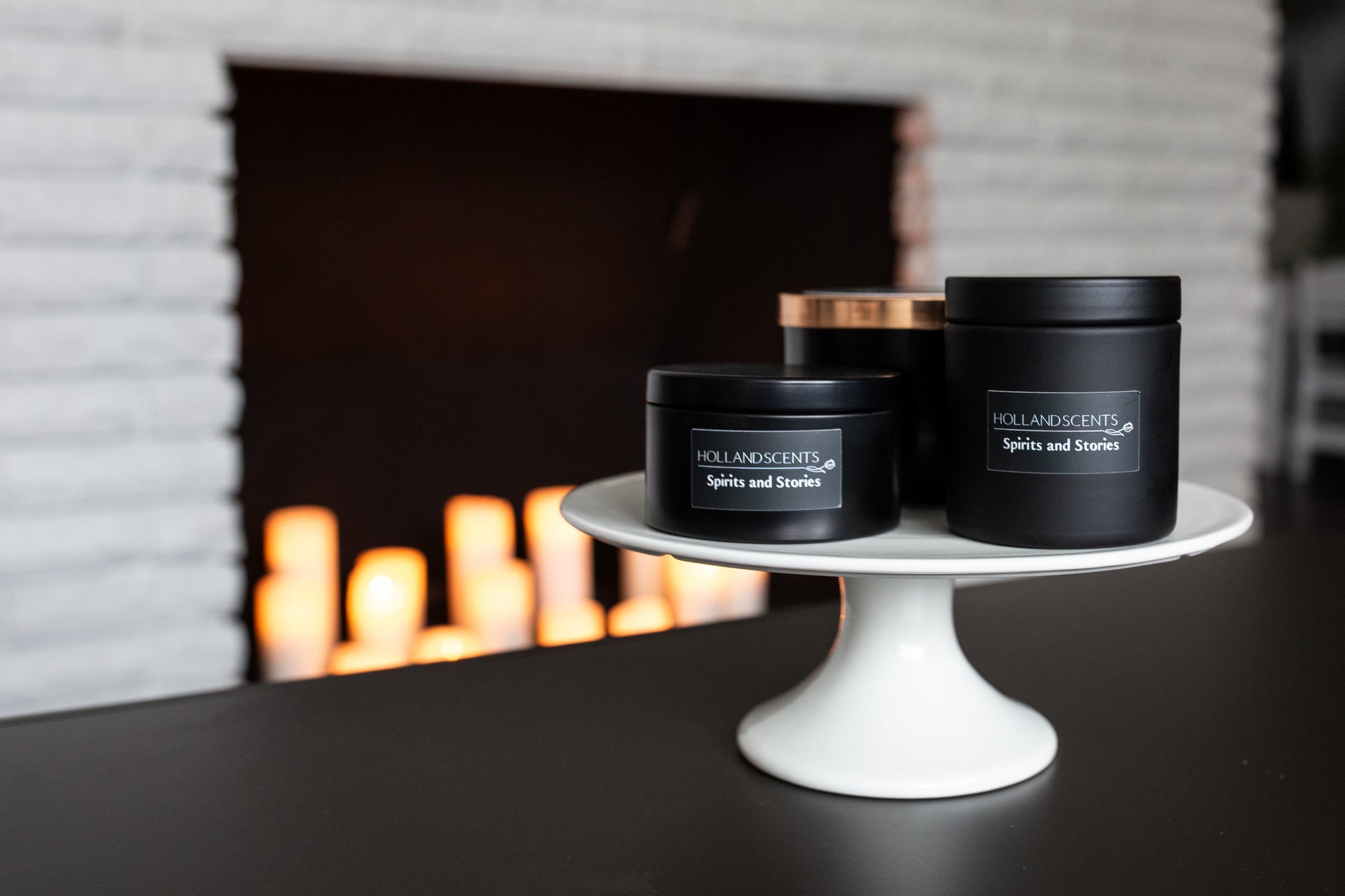 Holland Scents Spirits and Stories soy candle in three sizes displayed on a cake stand, Pella, Iowa