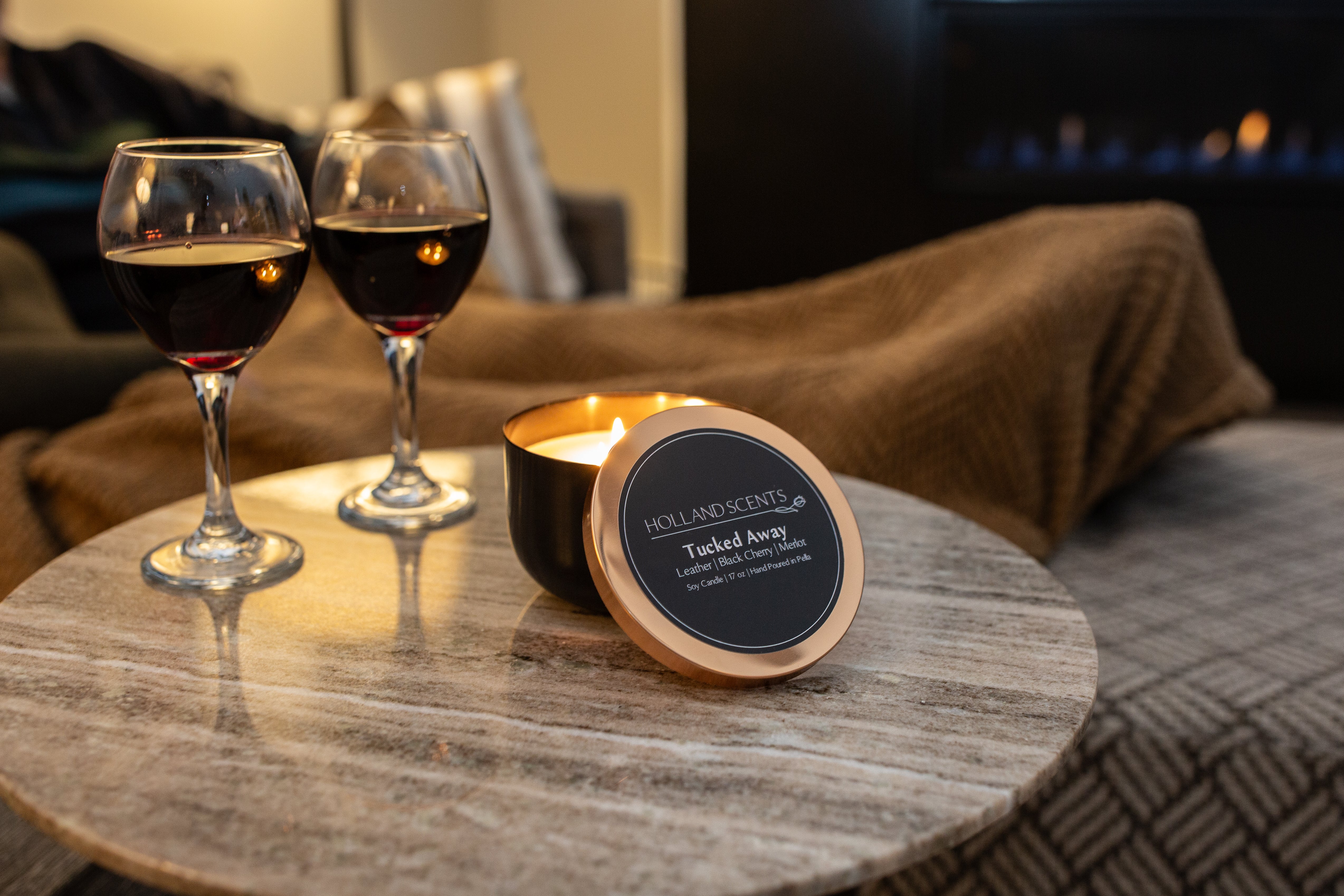 Holland Scents Tucked Away soy candle lit beside two glasses of red wine, Pella, Iowa