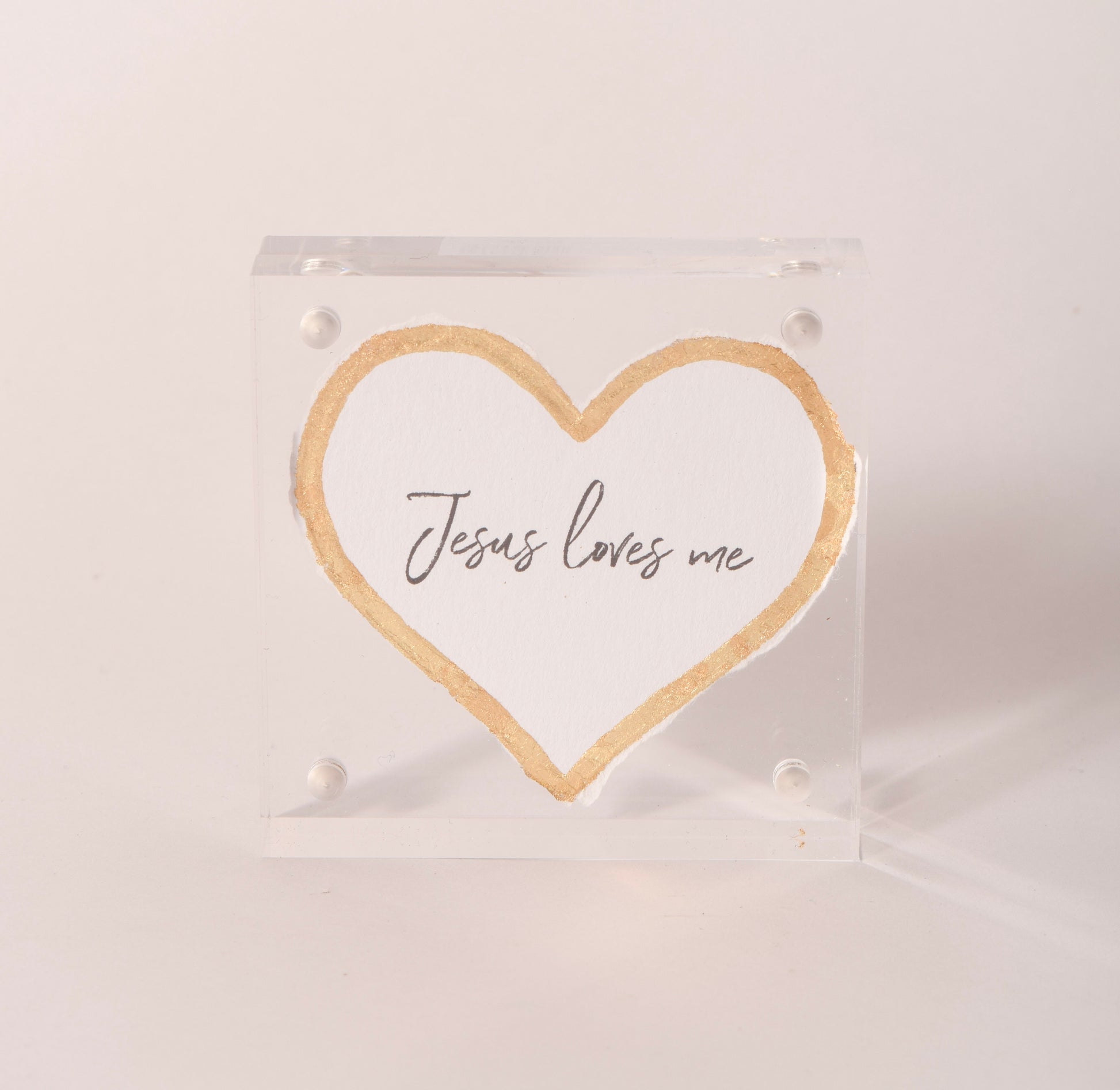 Clear acrylic keepsake with a gold-embossed "Jesus Loves Me" heart, sold at Thistles in Pella, Iowa