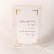 Clear acrylic plaque with gold corner accents reading "let your light shine," sold at Thistles in Pella, Iowa