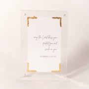 Clear acrylic plaque with gold corners inscribed with the Numbers 6:24-25 blessing, sold at Thistles in Pella, Iowa